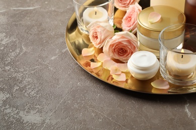 Photo of Composition with skin care products and roses on grey table, space for text