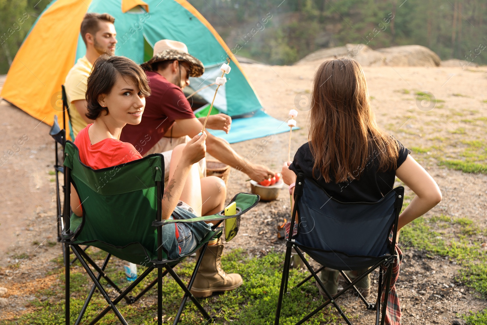 Photo of People having lunch near camping tent outdoors