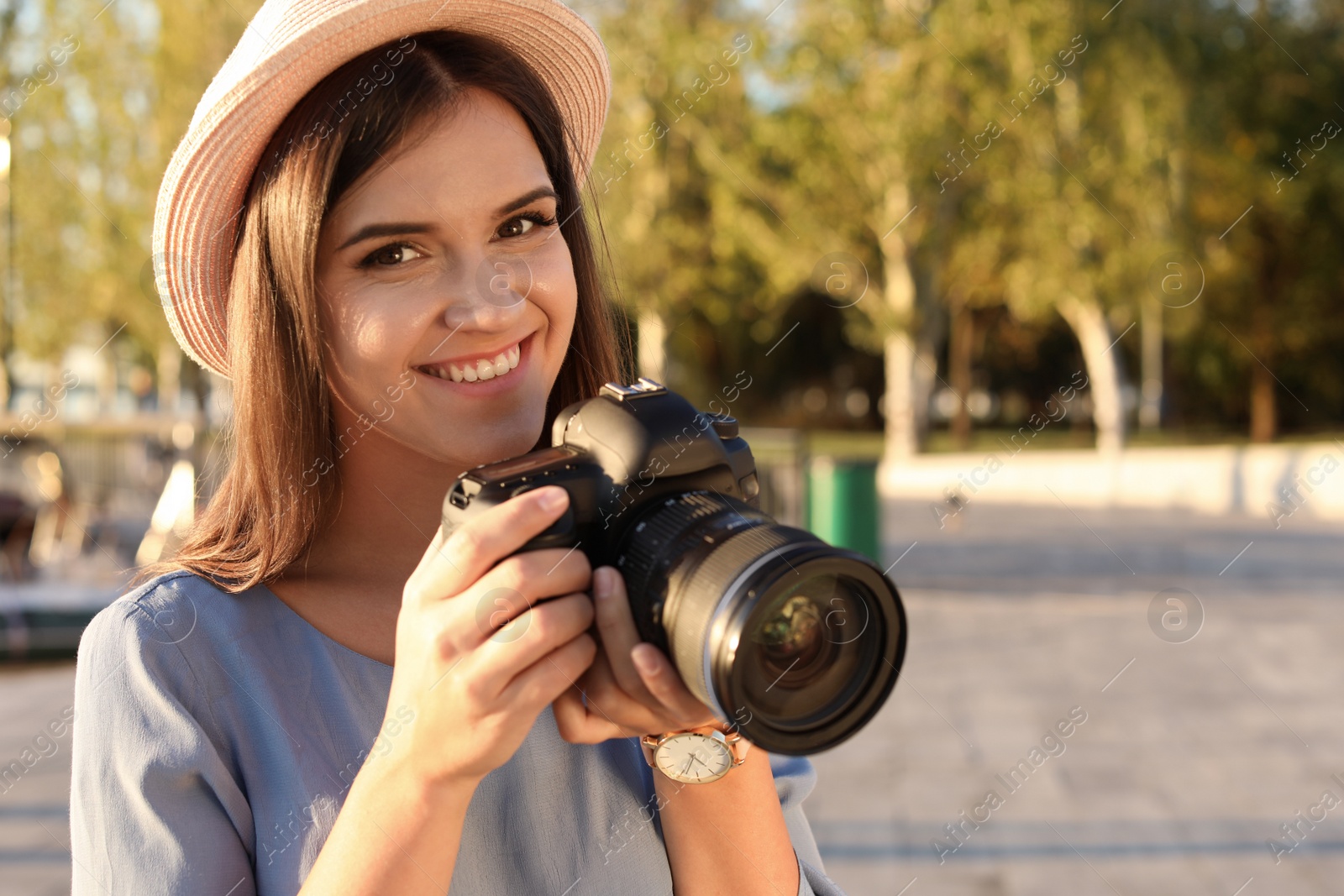 Photo of Young female photographer with professional camera on street. Space for text
