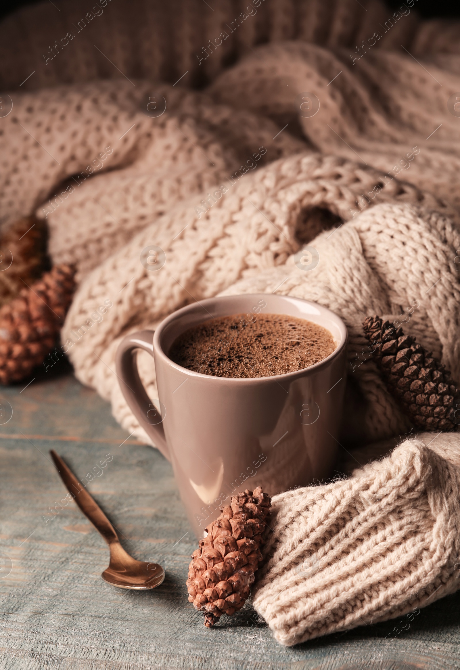 Photo of Composition with cup of hot cozy drink and autumn sweater on table