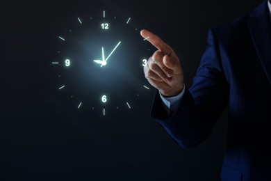 Image of Man holding virtual icon of clock on dark background, closeup. Time management