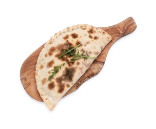 Wooden board with delicious calzone on white background, top view