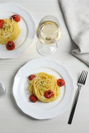 Tasty capellini with tomatoes and cheese served on white wooden table, flat lay. Exquisite presentation of pasta dish