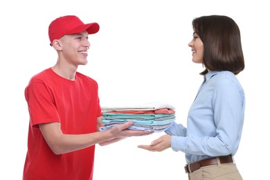 Image of Dry-cleaning delivery. Courier giving folded clothes to woman on white background