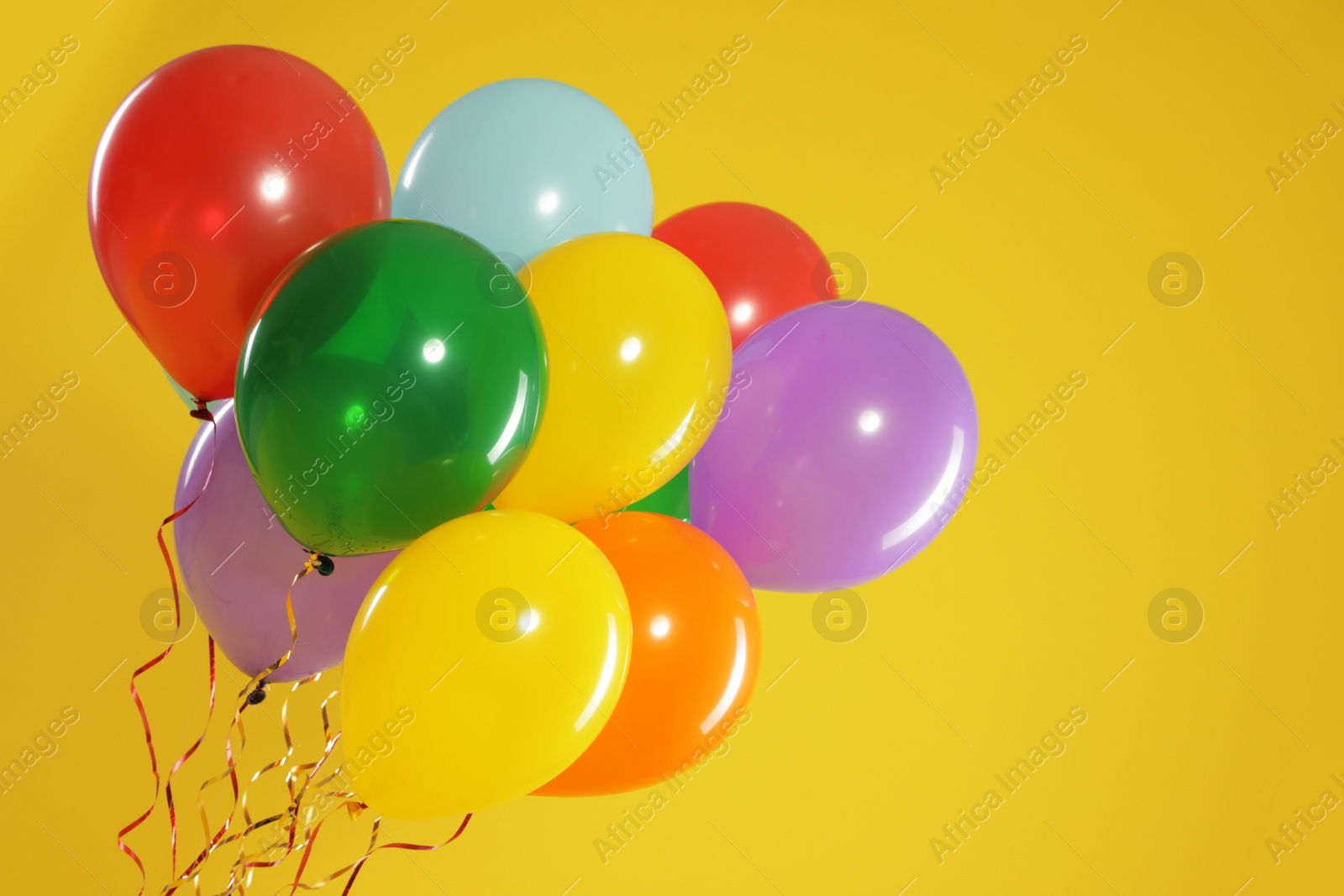 Photo of Bunch of bright balloons on color background, space for text. Celebration time