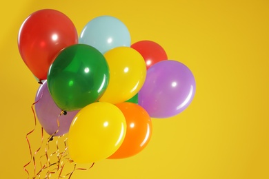 Bunch of bright balloons on color background, space for text. Celebration time