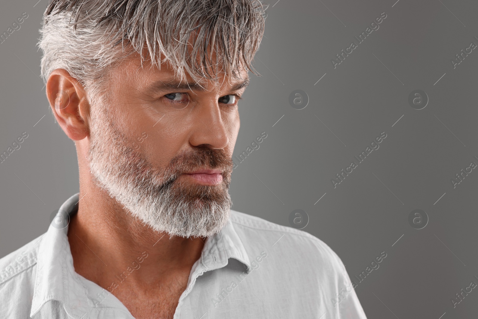 Photo of Portrait of confident man with beautiful hairstyle on light grey background. Space for text