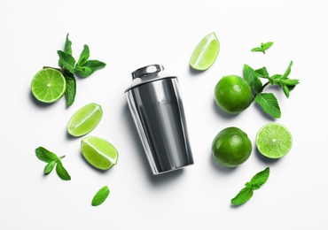 Flat lay composition with lime, mint and shaker on light background. Refreshing beverage ingredients