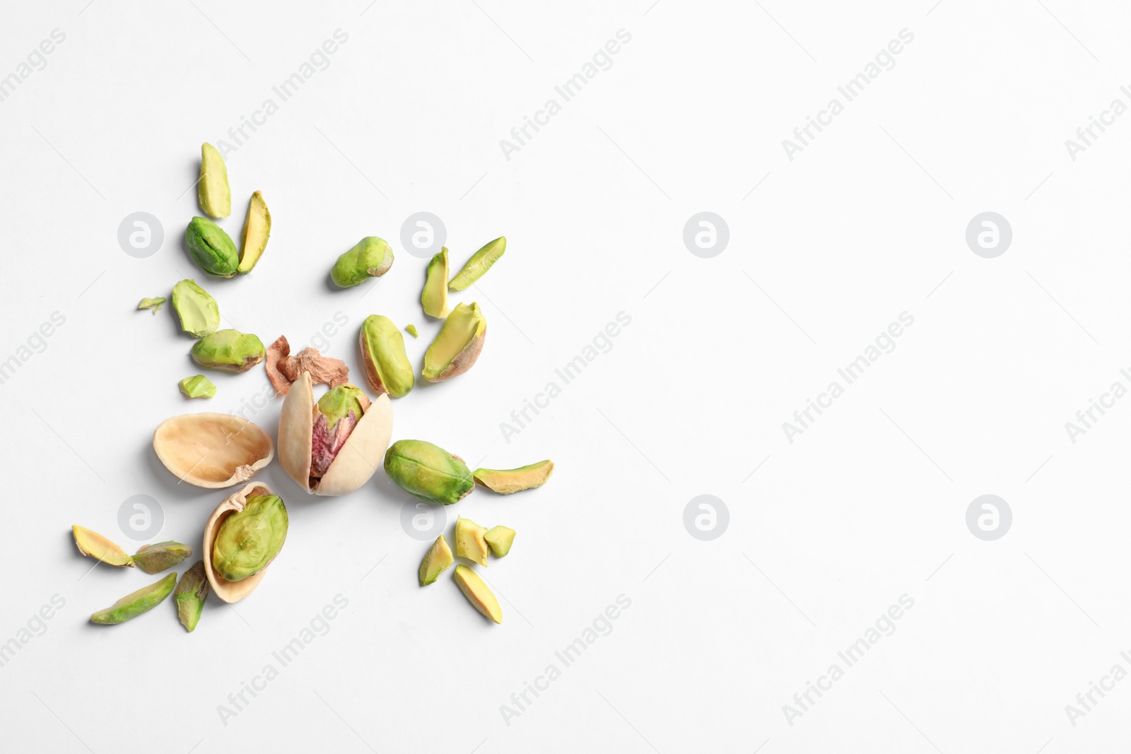 Photo of Composition with organic pistachio nuts on white background. Space for text