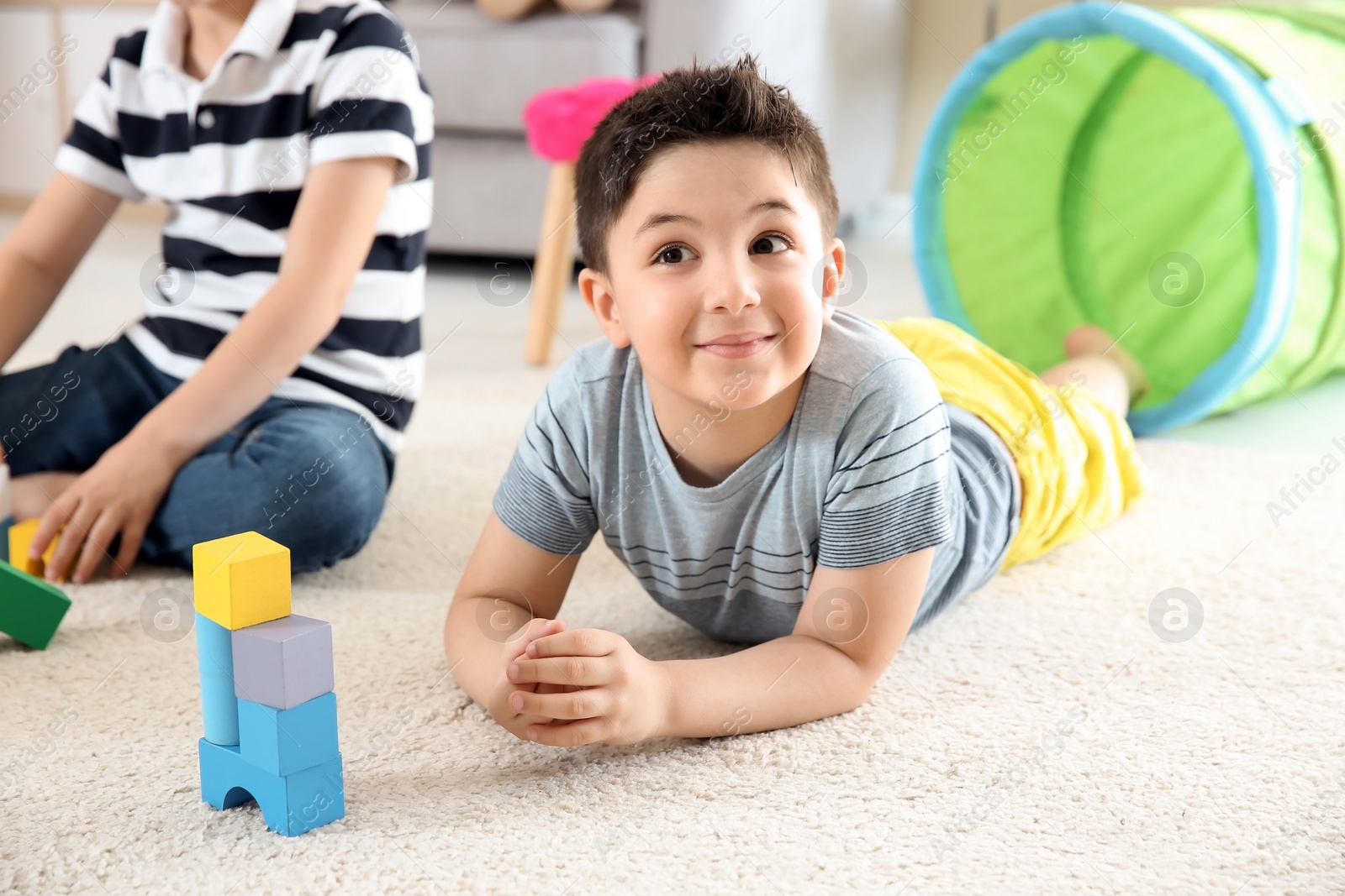 Photo of Cute little children playing with building blocks on floor, indoors