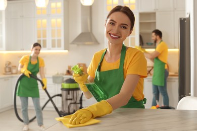 Photo of Team of professional janitors working in kitchen