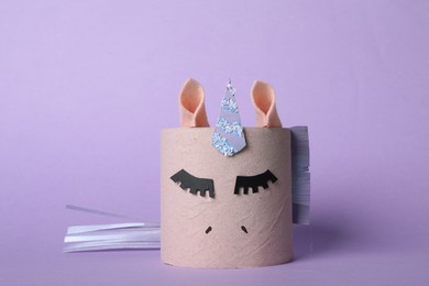Photo of Toy unicorn made of toilet paper roll on lilac background