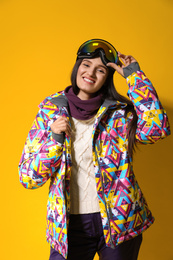 Photo of Woman wearing stylish winter sport clothes on yellow background