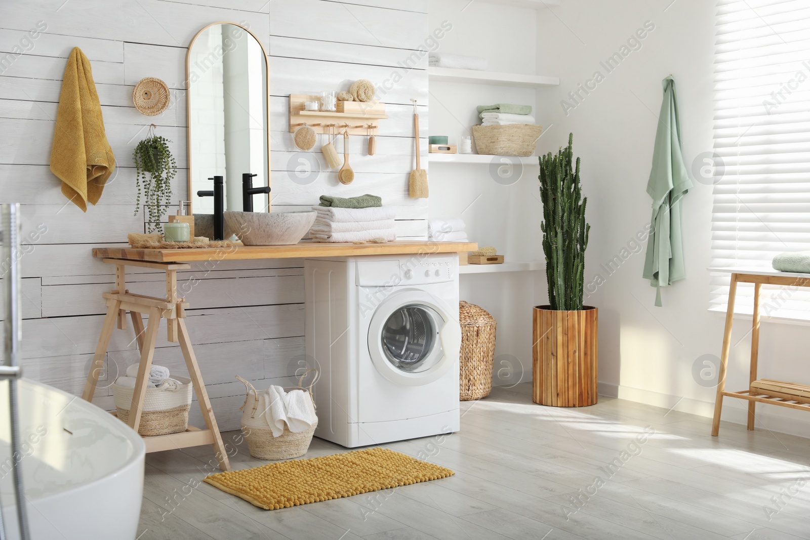 Photo of Stylish bathroom interior with modern washing machine