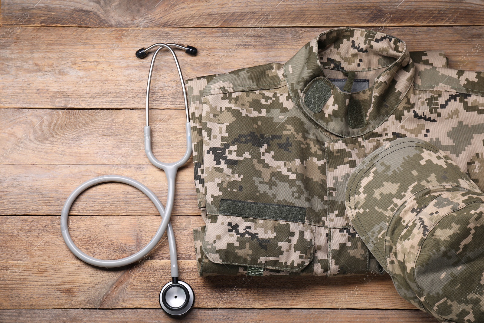 Photo of Stethoscope and military uniform on wooden background, flat lay