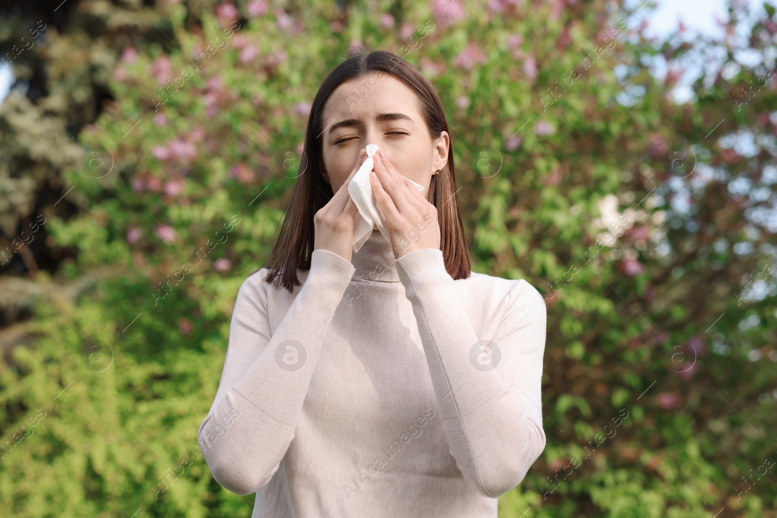 Photo of Woman with napkin suffering from seasonal allergy outdoors