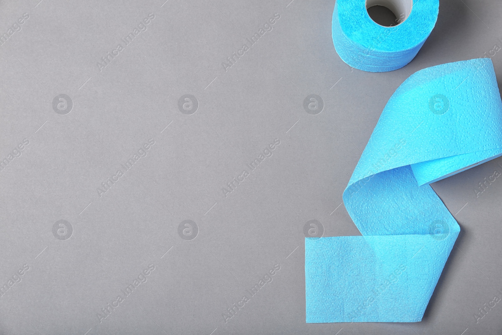 Photo of Rolls of toilet paper on grey background, top view. Space for text