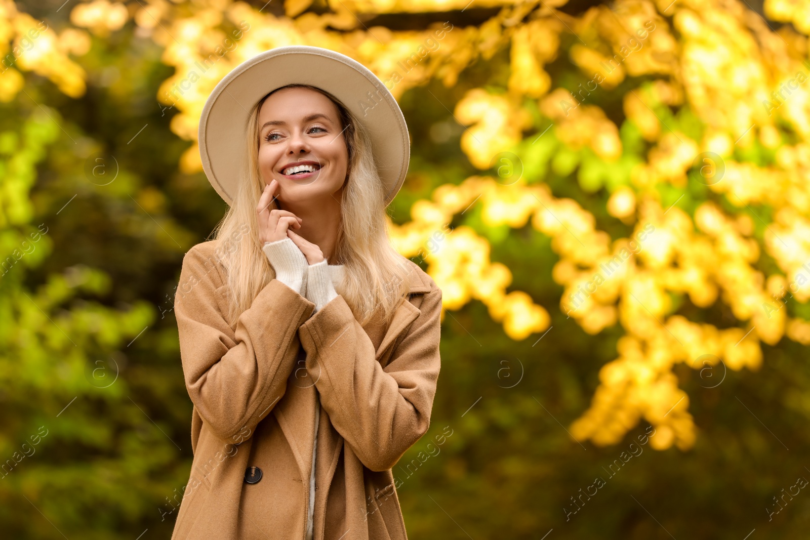 Photo of Portrait of happy woman in autumn park. Space for text