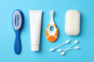 Photo of Flat lay composition with baby toothbrush and toiletries on color background