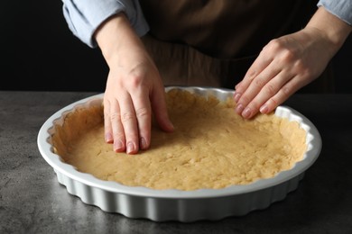 Shortcrust pastry. Woman making pie at grey table, closeup