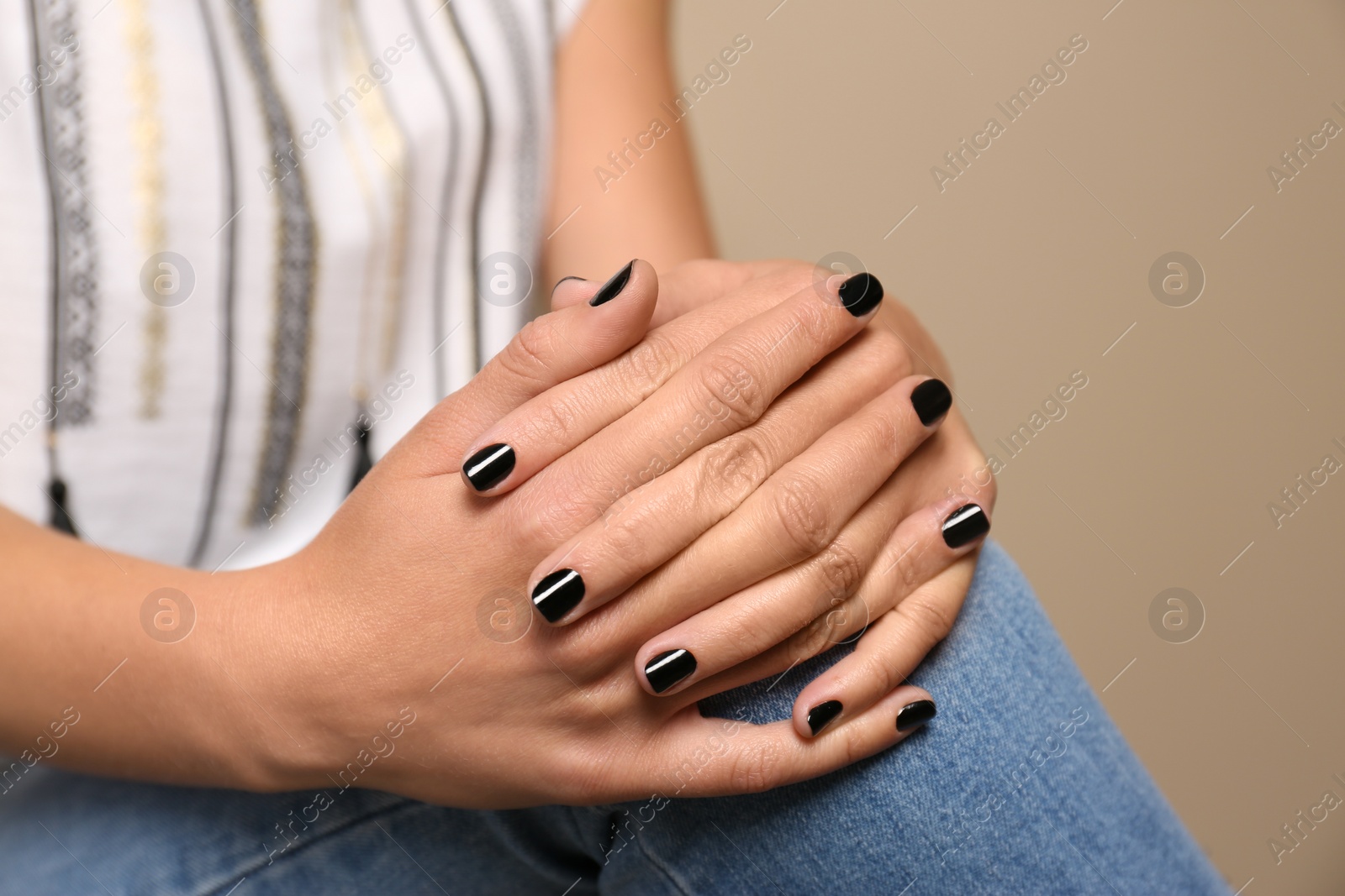 Photo of Woman with black manicure on color background, closeup. Nail polish trends