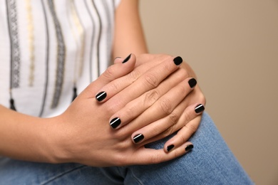 Photo of Woman with black manicure on color background, closeup. Nail polish trends