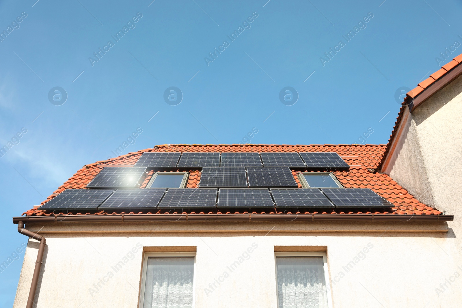 Photo of House with installed solar panels on roof. Alternative energy