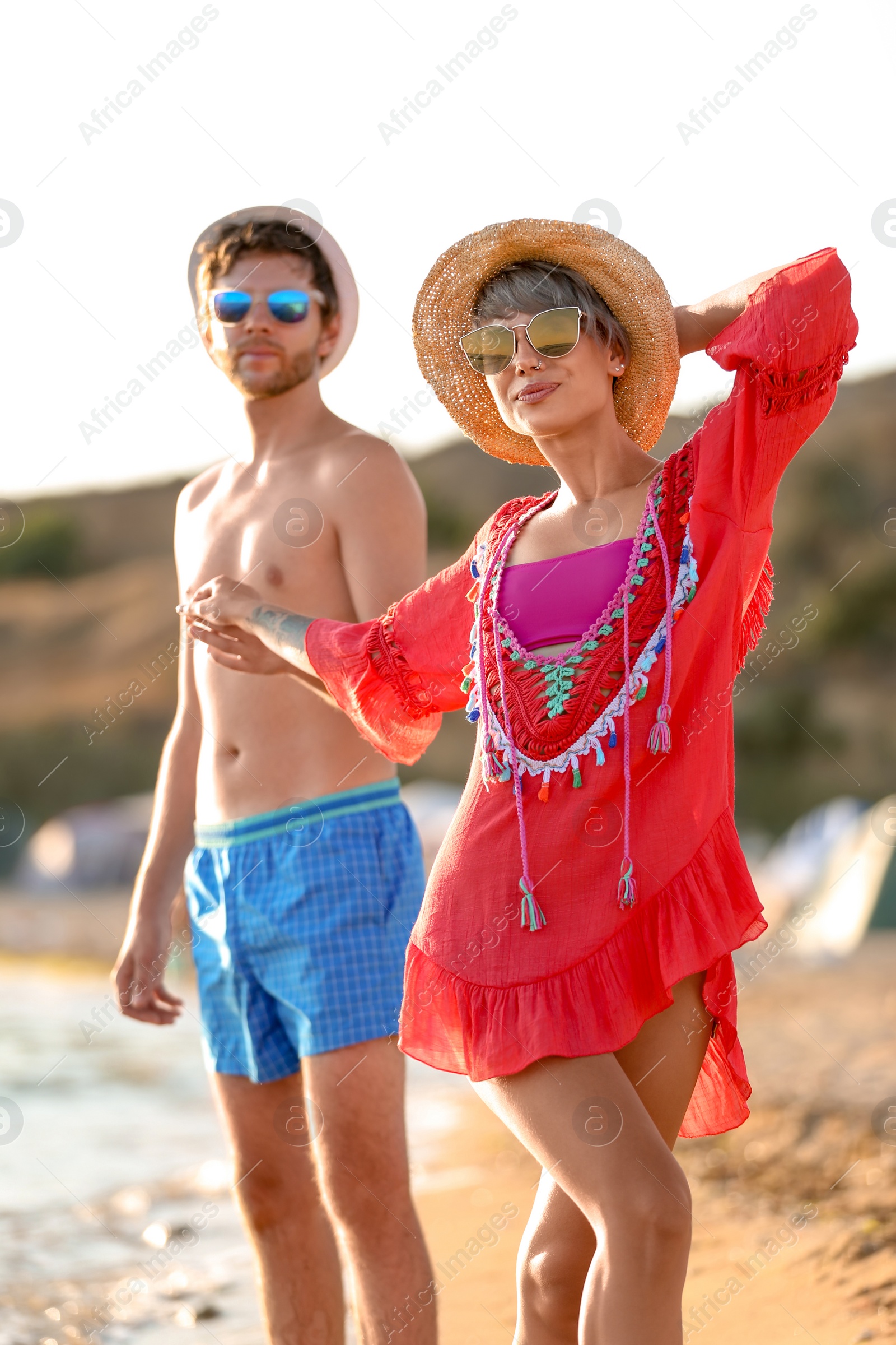 Photo of Happy young couple walking together on beach