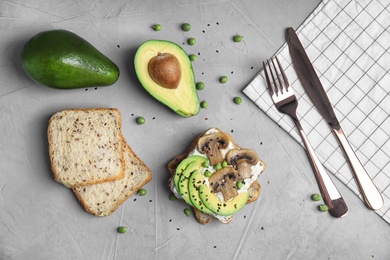 Flat lay composition with crisp toasts and avocado on table