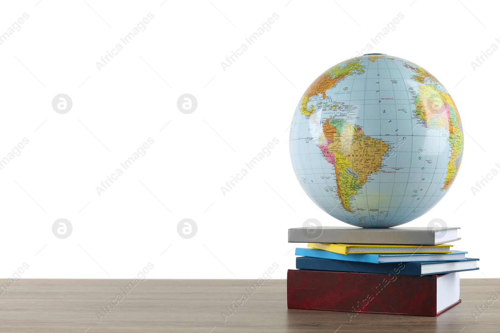 Photo of Globe and books on wooden table against white background. Geography lesson