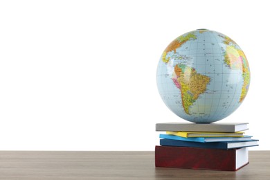 Globe and books on wooden table against white background. Geography lesson