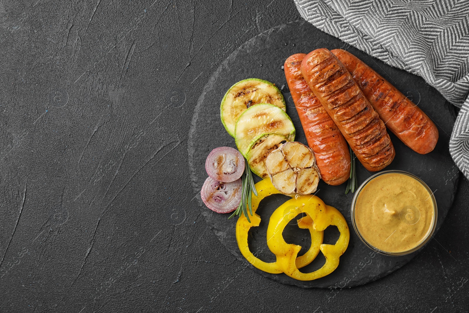 Photo of Flat lay composition with delicious grilled sausages on black table, space for text. Barbecue food