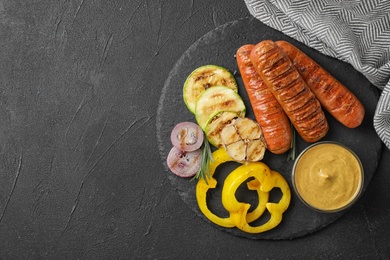 Photo of Flat lay composition with delicious grilled sausages on black table, space for text. Barbecue food