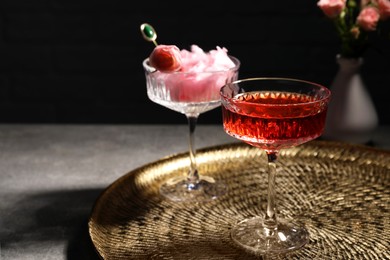 Photo of Glasses with rose wine and cotton candy on grey table