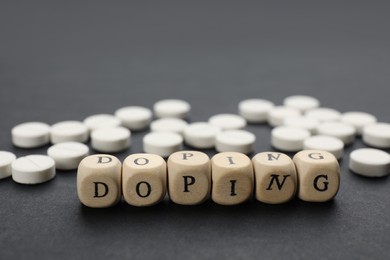 Photo of Wooden cubes with word Doping and drugs on black background, closeup