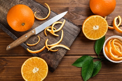 Orange fruits with peels on wooden table, flat lay