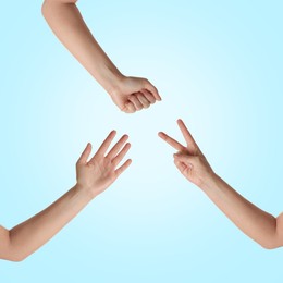 People playing rock, paper and scissors on light blue background, top view