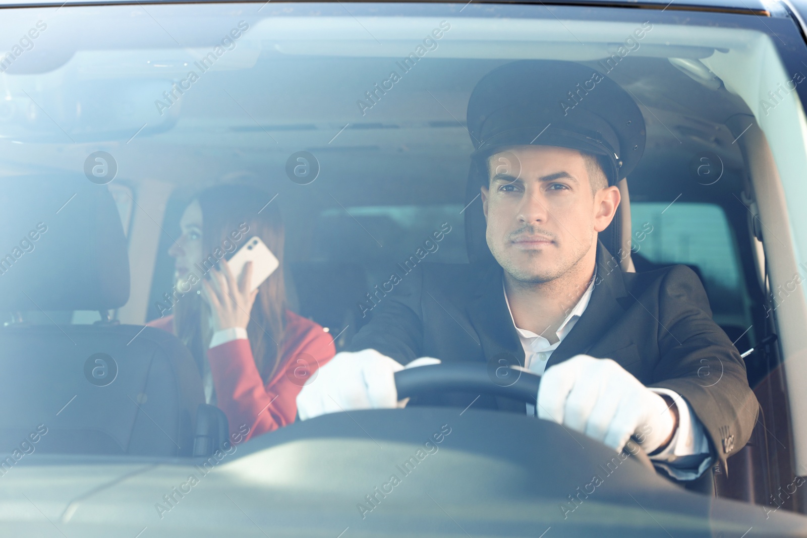 Photo of Professional driver and businesswoman in luxury car. Chauffeur service