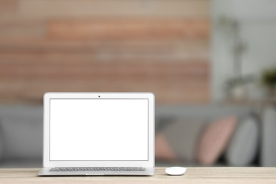 Laptop with blank screen on table indoors. Space for text