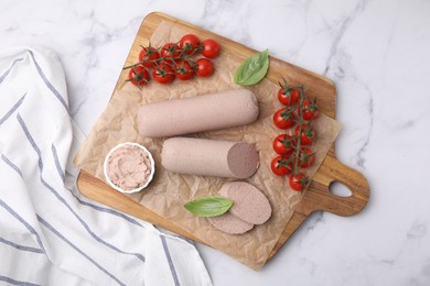 Delicious liver sausages, paste and cherry tomatoes on white marble table, top view