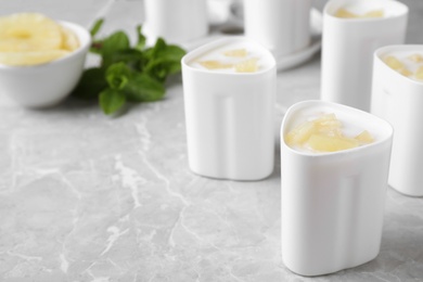 Photo of Cups of pineapple yogurt and ingredients on table, space for text. Multi cooker recipe