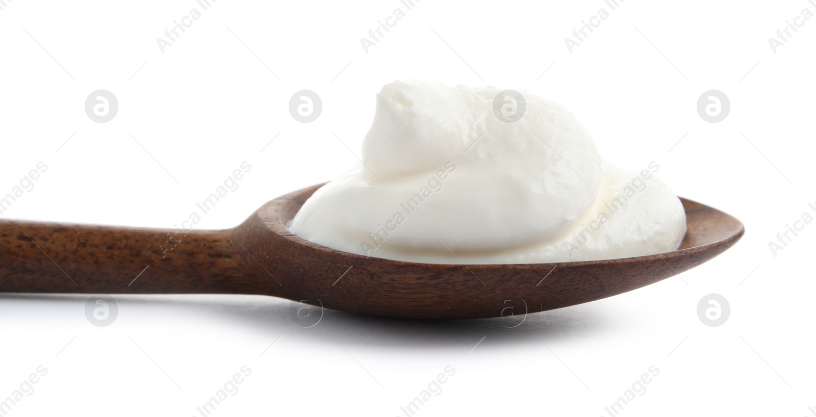 Photo of Wooden spoon with sour cream on white background