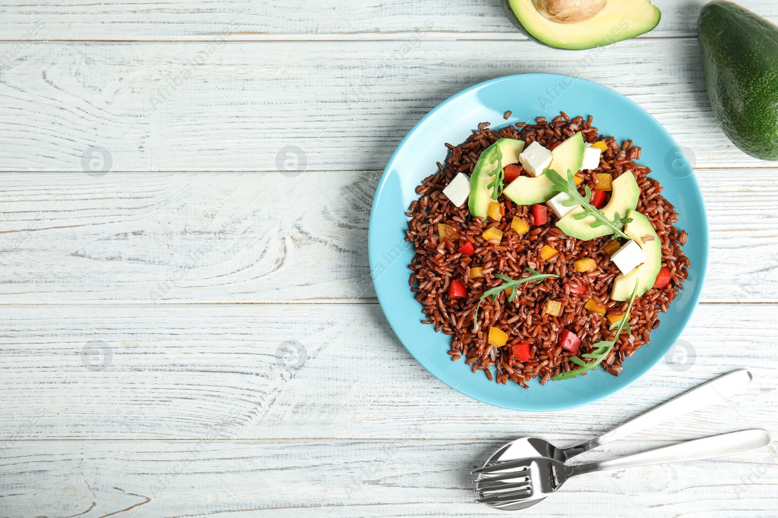 Photo of Flat lay composition with delicious cooked brown rice on white wooden table. Space for text