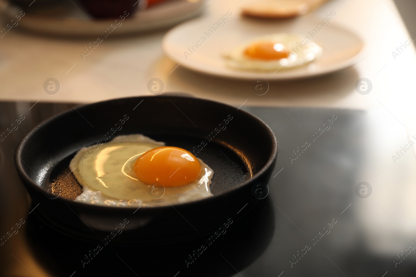 Photo of Frying pan with fresh egg on stove, space for text