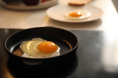 Frying pan with fresh egg on stove, space for text