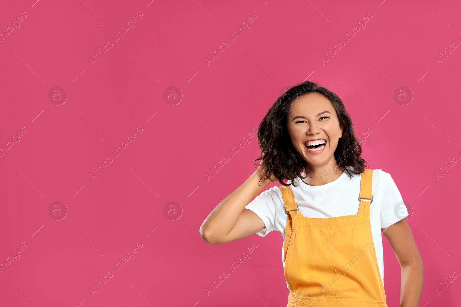 Photo of Happy young woman in casual outfit on pink background. Space for text