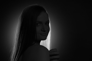 Image of Silhouette of woman in darkness. Portrait on black background