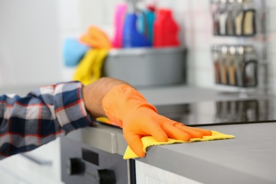 Photo of Man cleaning kitchen counter with rag, closeup