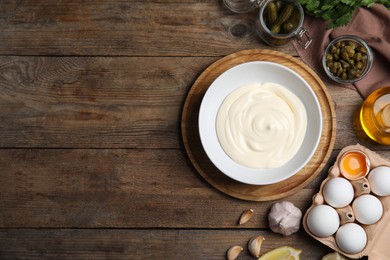 Flat lay composition with tartar sauce ingredients on wooden table, space for text