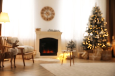 Photo of Beautiful living room interior with decorated Christmas tree and modern fireplace, blurred view